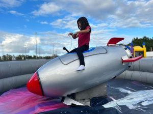 girl riding mechanical rocket ship ride